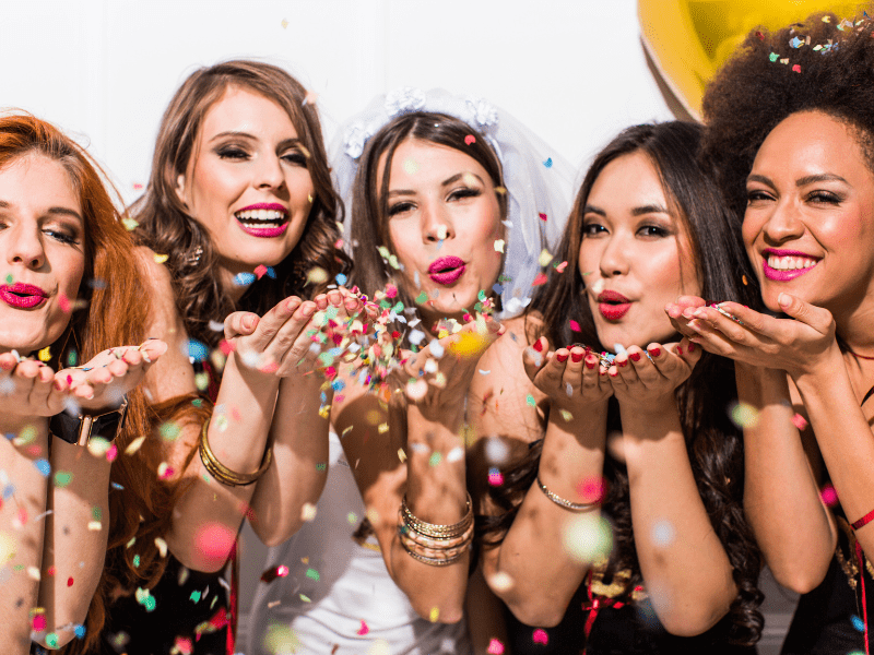Femmes soufflant sur des confettis lors d'un EVJF