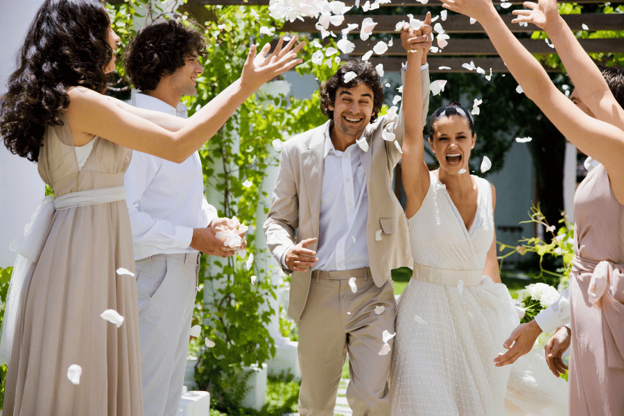 Les mariés sortant de la cérémonie de mariage, les invités jettent des pétales de roses